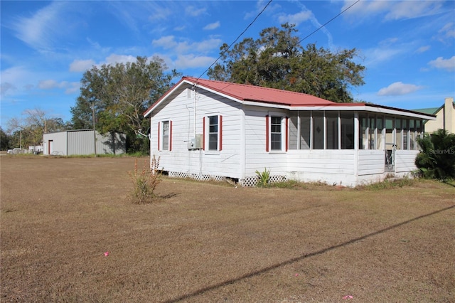 exterior space with a sunroom and a yard