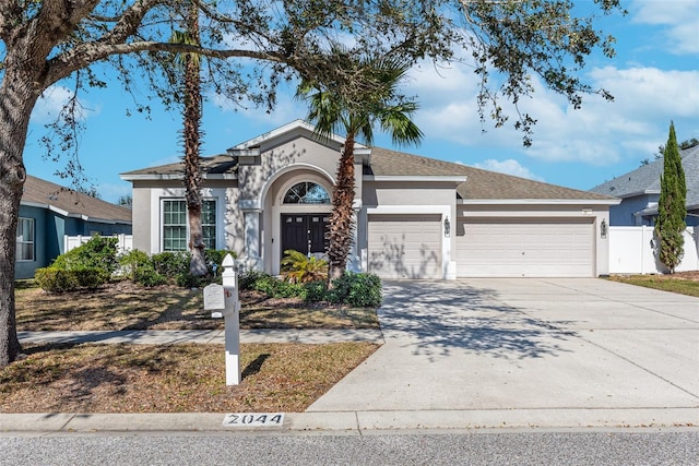 view of front of house with concrete driveway, an attached garage, and stucco siding