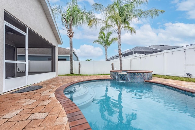 view of swimming pool with an in ground hot tub, pool water feature, a patio, and a sunroom