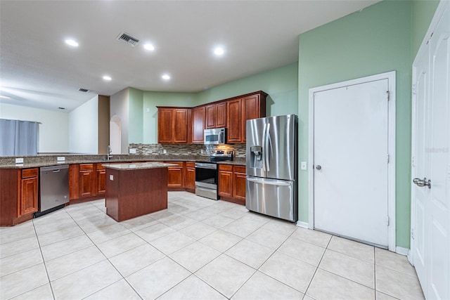 kitchen featuring a kitchen island, appliances with stainless steel finishes, tasteful backsplash, sink, and kitchen peninsula