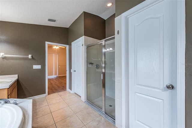 bathroom featuring tile patterned flooring, vanity, shower with separate bathtub, and a textured ceiling