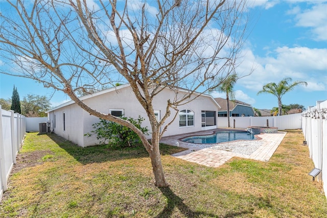 back of house featuring a swimming pool with hot tub, a patio, a yard, and central air condition unit