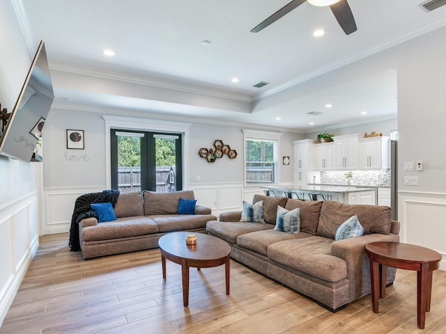 living room with ornamental molding, ceiling fan, light wood-type flooring, and french doors