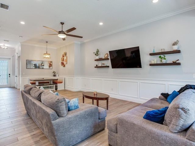 living room featuring ornamental molding, ceiling fan, and light hardwood / wood-style flooring