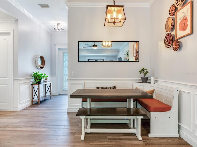 dining area featuring hardwood / wood-style flooring, crown molding, a chandelier, and breakfast area