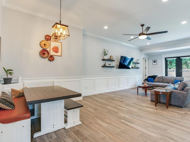 living room with crown molding, ceiling fan, and light wood-type flooring