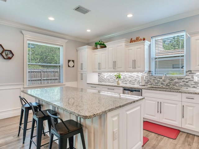 kitchen with sink, a kitchen island, and white cabinets