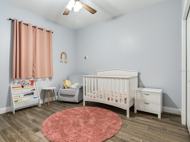 bedroom with ceiling fan and a crib