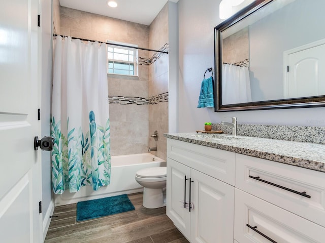 full bathroom with wood-type flooring, toilet, shower / bath combination with curtain, and vanity