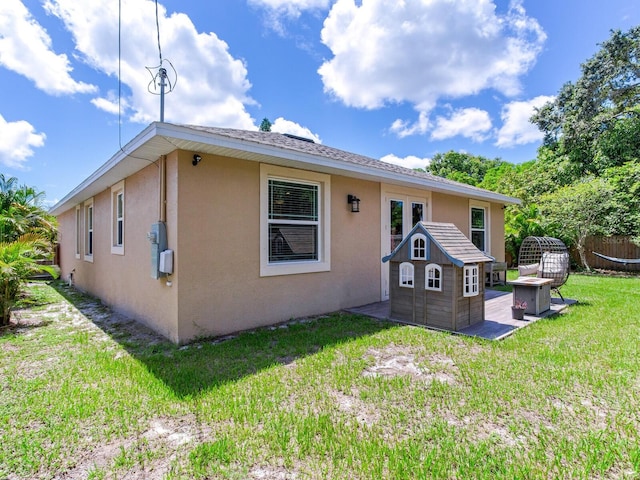 rear view of property with a yard and an outdoor structure