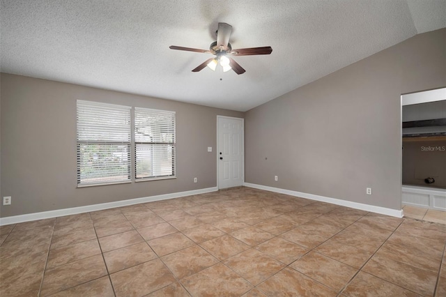 tiled empty room featuring lofted ceiling, a textured ceiling, and ceiling fan