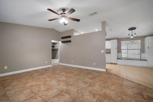 unfurnished living room with light tile patterned flooring, lofted ceiling, ceiling fan with notable chandelier, and a textured ceiling