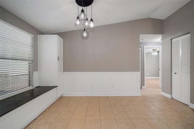 tiled spare room featuring lofted ceiling and ceiling fan