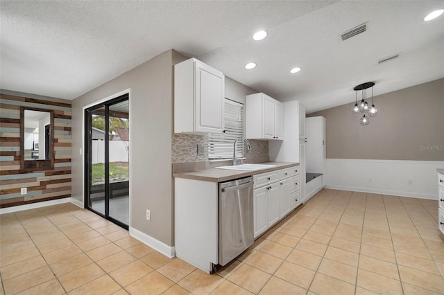 kitchen featuring sink, white cabinetry, hanging light fixtures, light tile patterned floors, and stainless steel dishwasher