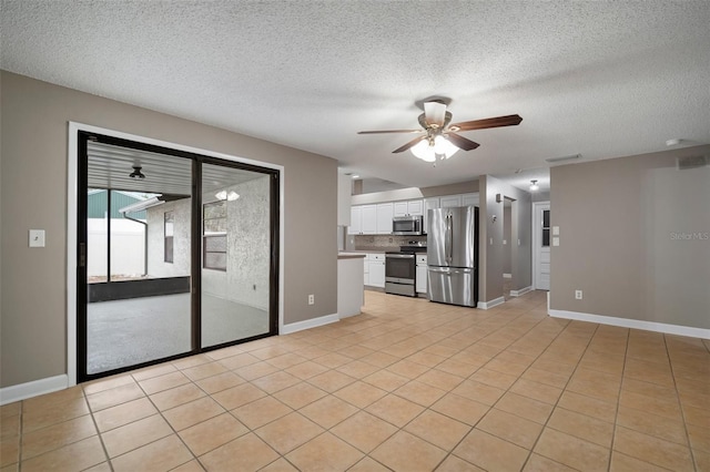 unfurnished living room featuring ceiling fan, a textured ceiling, and light tile patterned floors