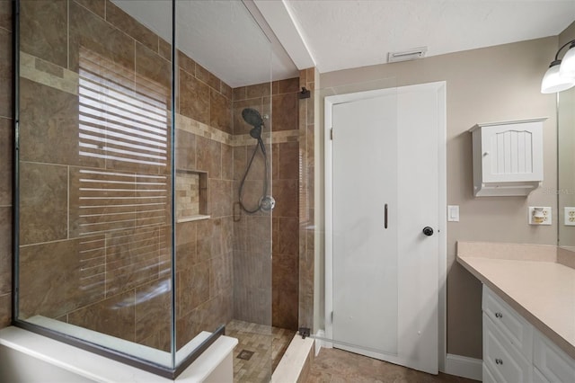 bathroom with vanity and a tile shower