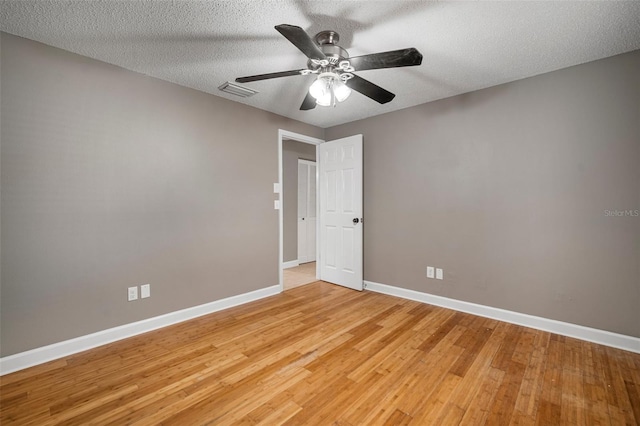 empty room featuring ceiling fan, light hardwood / wood-style floors, and a textured ceiling