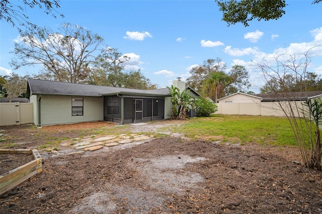 rear view of property featuring a lawn and a sunroom