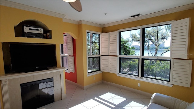 tiled living room with crown molding, a fireplace, and a water view