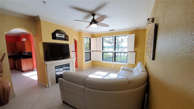 tiled living room with ornamental molding and ceiling fan