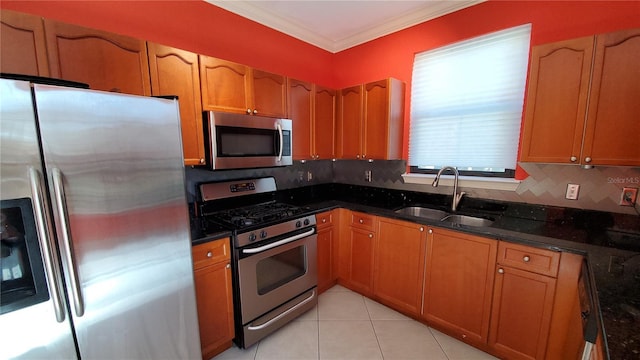 kitchen featuring sink, appliances with stainless steel finishes, light tile patterned flooring, decorative backsplash, and dark stone counters