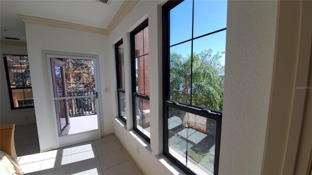 doorway to outside with ornamental molding and light tile patterned floors