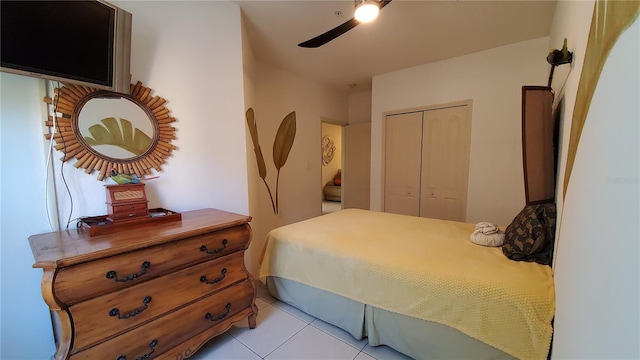 tiled bedroom with ceiling fan and a closet