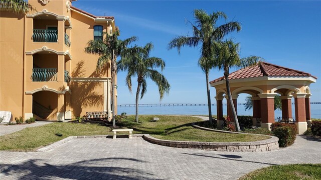 surrounding community with a water view and a yard