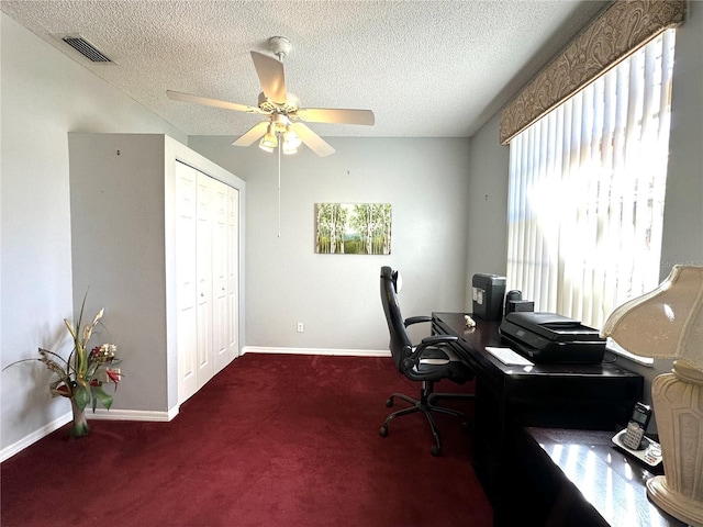 carpeted office space featuring ceiling fan and a textured ceiling