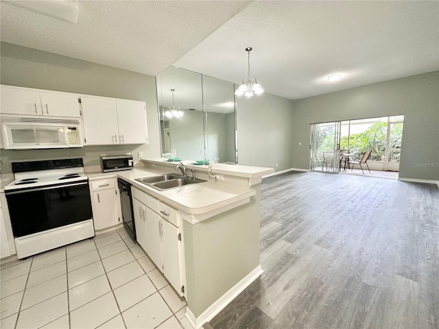 2116 Nantucket Dr Unit 19, Sun City Center, FL 33573 - kitchen with a sink, electric range oven, white microwave, light countertops, and a peninsula