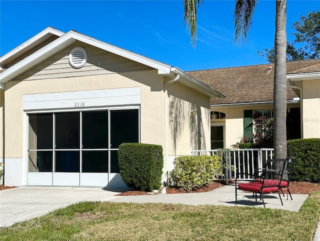 2116 Nantucket Dr Unit 19, Sun City Center, FL 33573 - rear view of house with roof with shingles and stucco siding