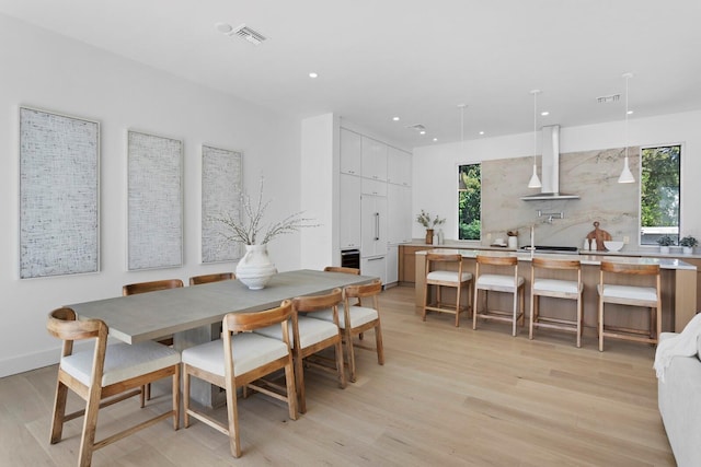 dining room featuring sink and light hardwood / wood-style floors