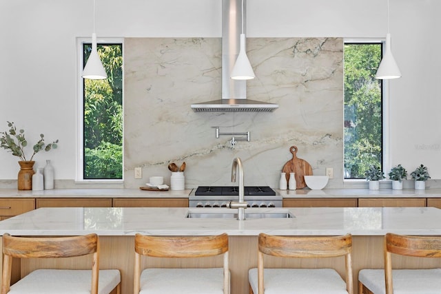 kitchen with a breakfast bar, a healthy amount of sunlight, and pendant lighting