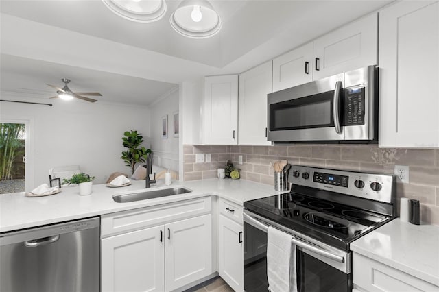 kitchen featuring sink, decorative backsplash, stainless steel appliances, and white cabinets