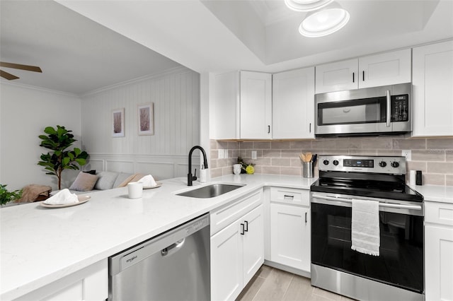 kitchen with white cabinetry, sink, ceiling fan, light hardwood / wood-style floors, and stainless steel appliances