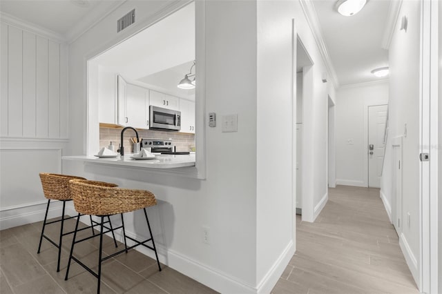 corridor featuring ornamental molding and light hardwood / wood-style floors