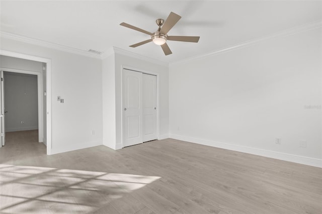 unfurnished bedroom featuring crown molding, light wood-type flooring, ceiling fan, and a closet