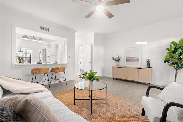 living room with crown molding, ceiling fan, and light hardwood / wood-style floors