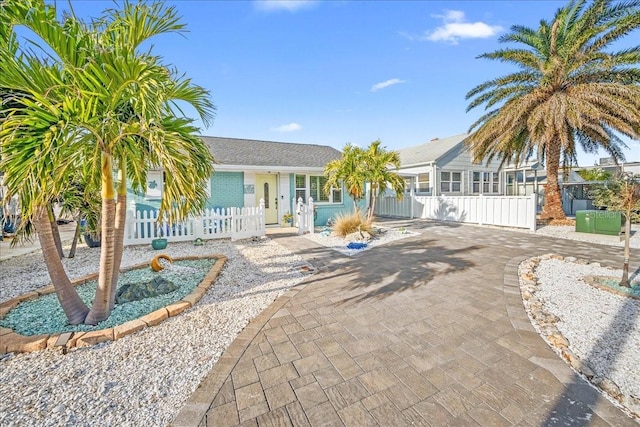 ranch-style house with a fenced front yard and a gate