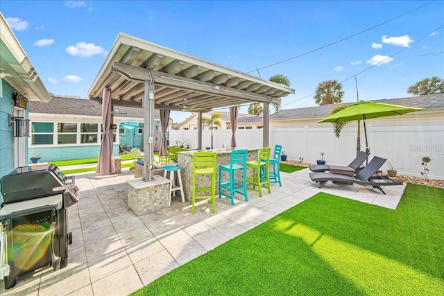 view of patio / terrace with outdoor dry bar, area for grilling, and a fenced backyard