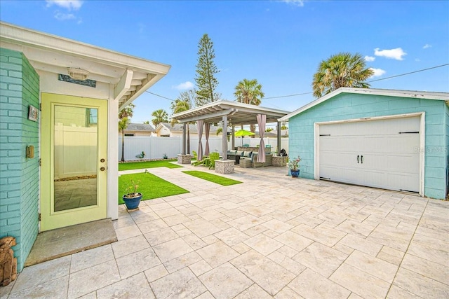 view of patio / terrace featuring an outbuilding, a garage, fence, an outdoor living space, and concrete driveway