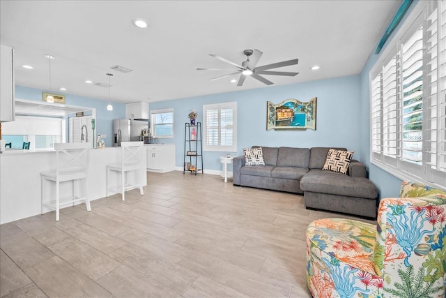 living room with light wood finished floors, a ceiling fan, visible vents, and recessed lighting