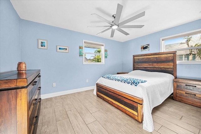 bedroom with light wood-style flooring, baseboards, and a ceiling fan