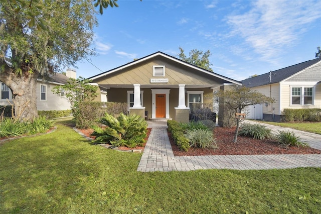 view of front of home with a front yard and a porch