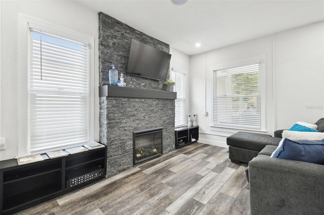 living room with hardwood / wood-style floors, a wealth of natural light, and a fireplace