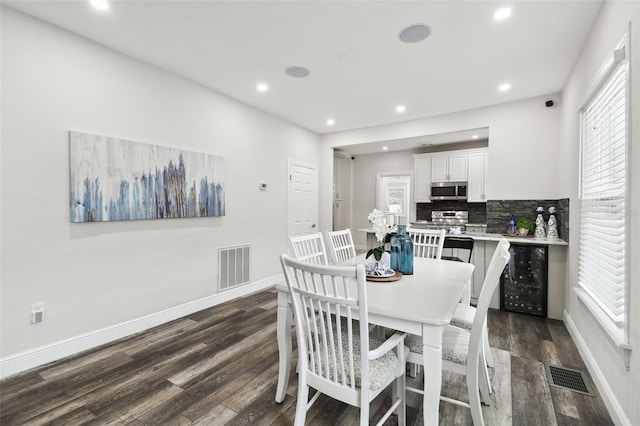 dining space with dark wood-type flooring and beverage cooler