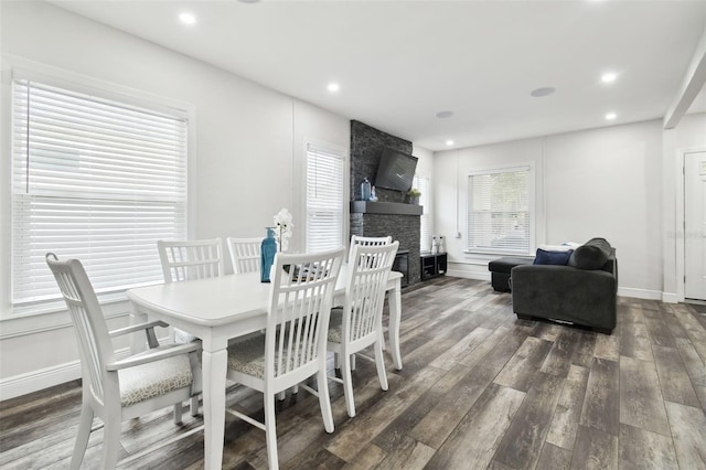 dining space with dark hardwood / wood-style floors and a fireplace