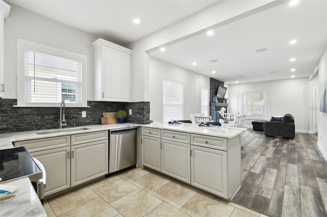 kitchen featuring sink, stainless steel appliances, tasteful backsplash, white cabinets, and kitchen peninsula