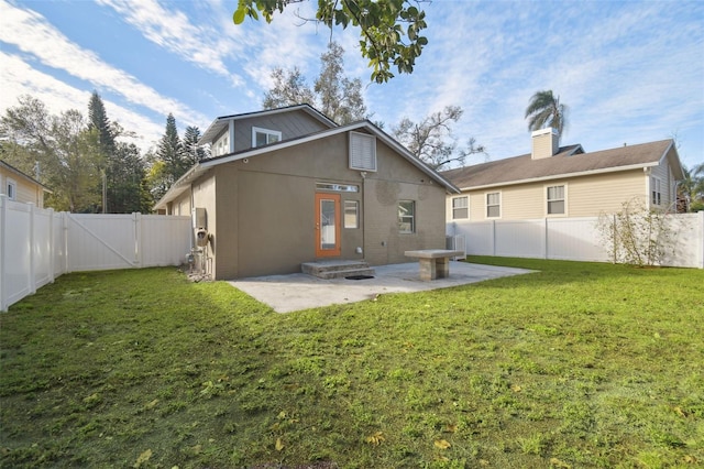 rear view of property featuring a lawn and a patio area