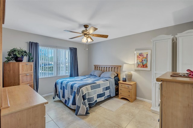 tiled bedroom featuring ceiling fan